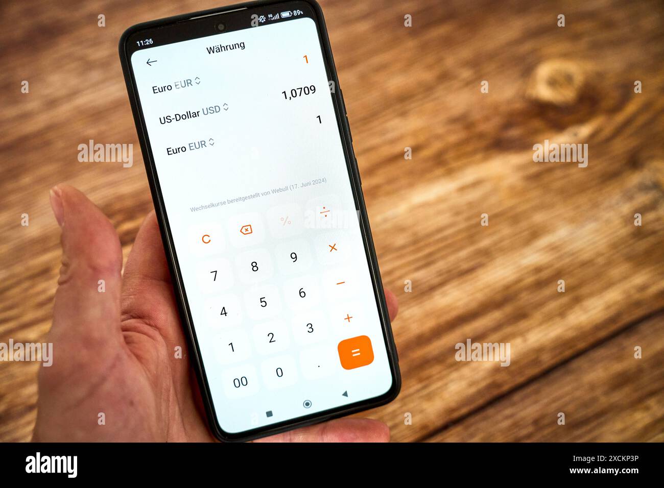 Germania - 17 giugno 2024: L'app per il convertitore di valuta è aperta su uno smartphone o un telefono cellulare. Viene effettuato un calcolo del tasso di cambio attuale rispetto all'euro e al dollaro. *** Währungsrechner App ist auf einem smartphone, bzw. Pratico geöffnet. Eine Berechnung des aktuellen Wechselkurses im Bezug auf Euro und Dollar findet statt. Foto Stock