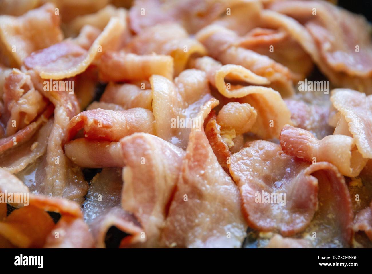 Bacon sfrigolante in una padella Foto Stock