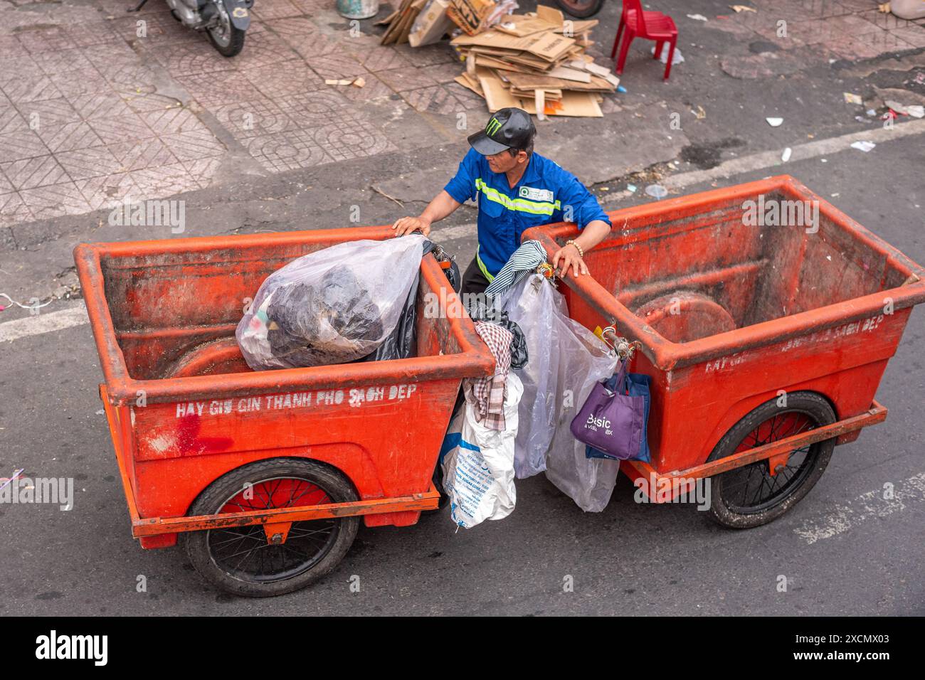 Ho chi Minh City, Vietnam – 28 maggio 2024: Un operatore sanitario spinge due bidoni. Foto Stock