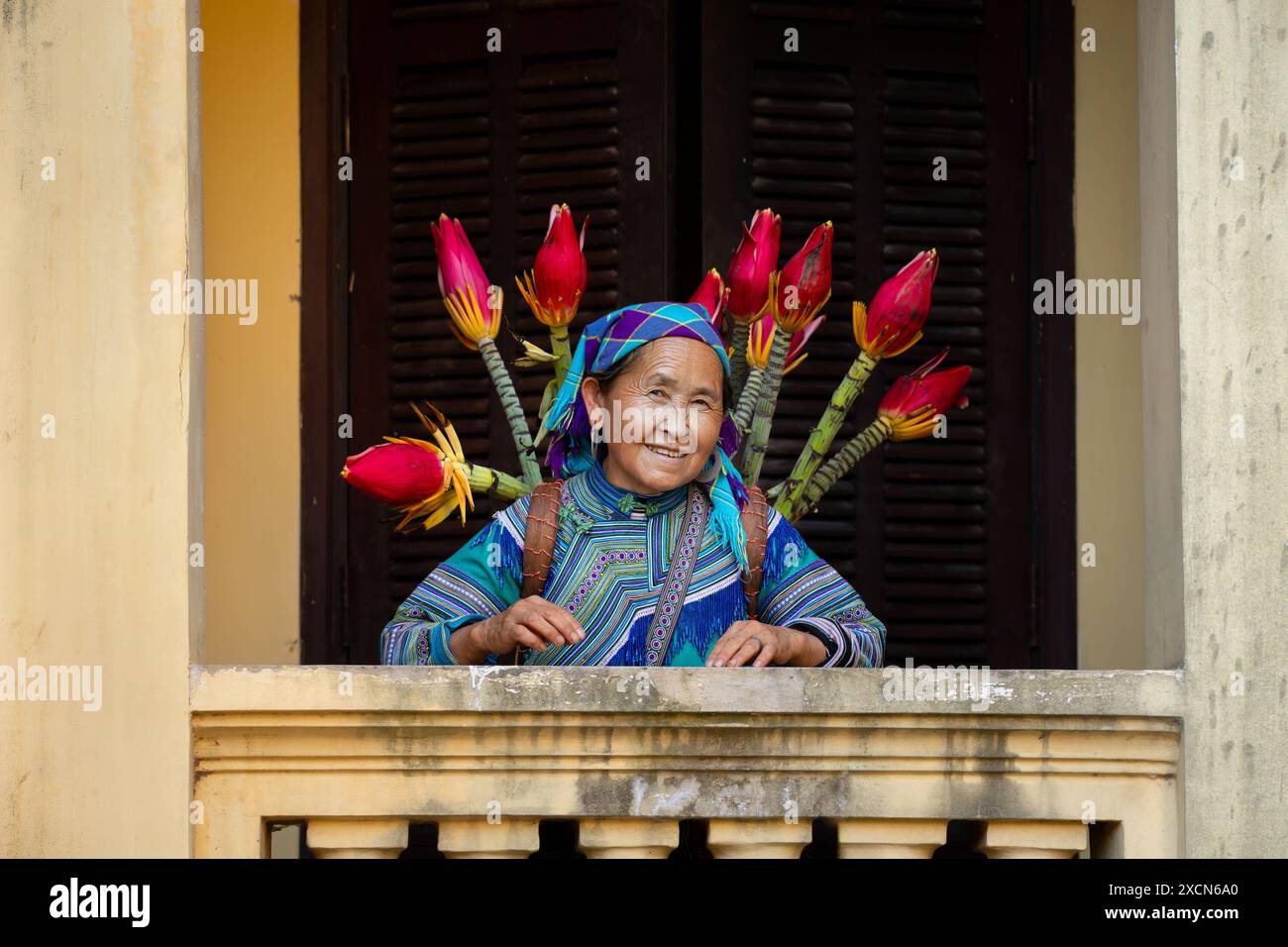 Donna Hmong di fiori che porta un cesto di fiori nel Palazzo dei Re Hmong (Vau Meo) a Bac ha, provincia di Lao Cai, Vietnam Foto Stock