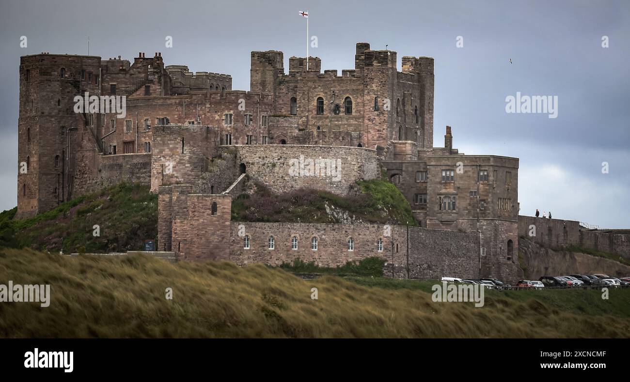 Il castello di Bamburgh, situato lungo la costa del Mare del Nord, nell'Inghilterra settentrionale, è un esempio di architettura normanna costruita nell'XI secolo. Foto Stock