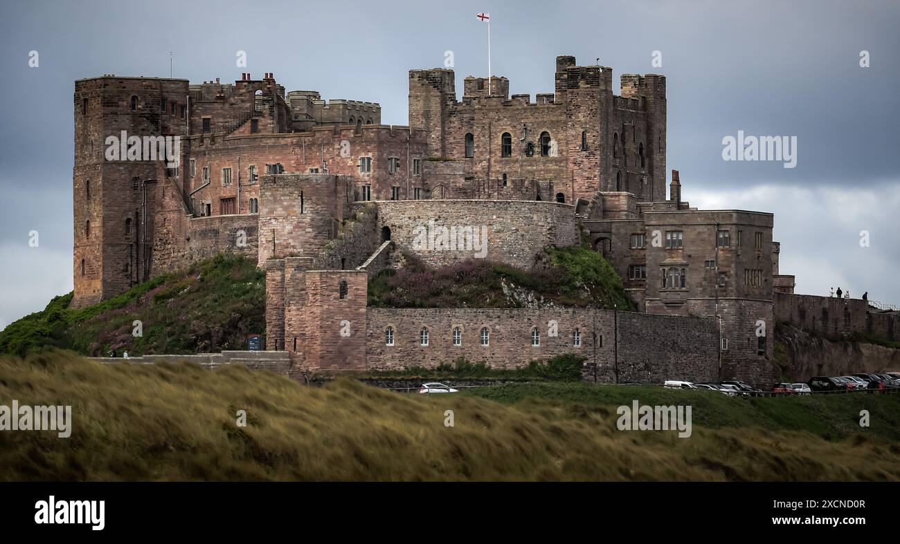 Il castello di Bamburgh, situato lungo la costa del Mare del Nord, nell'Inghilterra settentrionale, è un esempio di architettura normanna costruita nell'XI secolo. Foto Stock