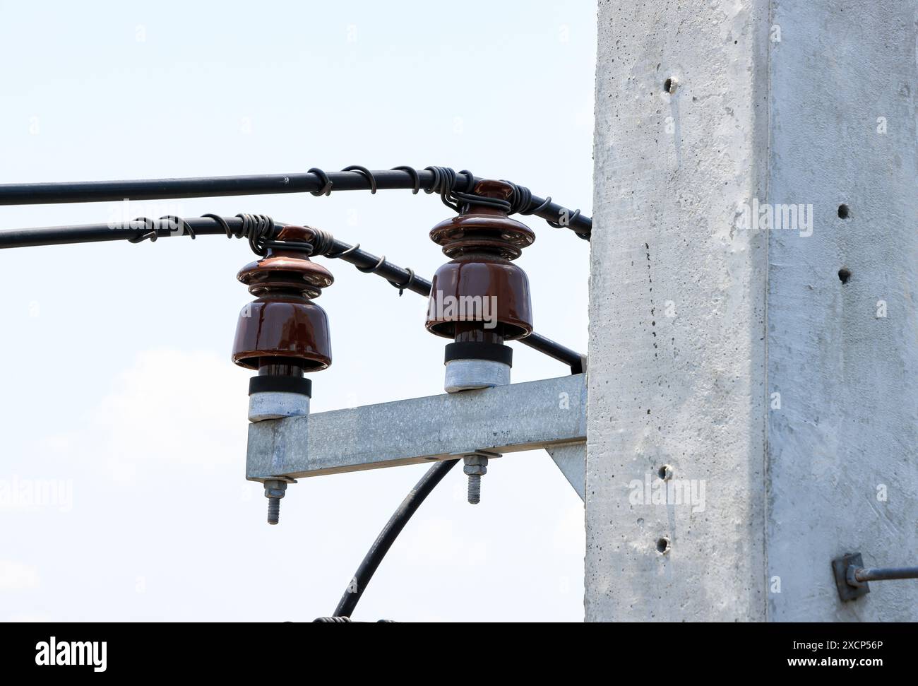 Vista ravvicinata del polo ad alta tensione, torre ad alta tensione, mostra con struttura ad alta tensione e linee elettriche, con sfondo blu cielo. Foto Stock