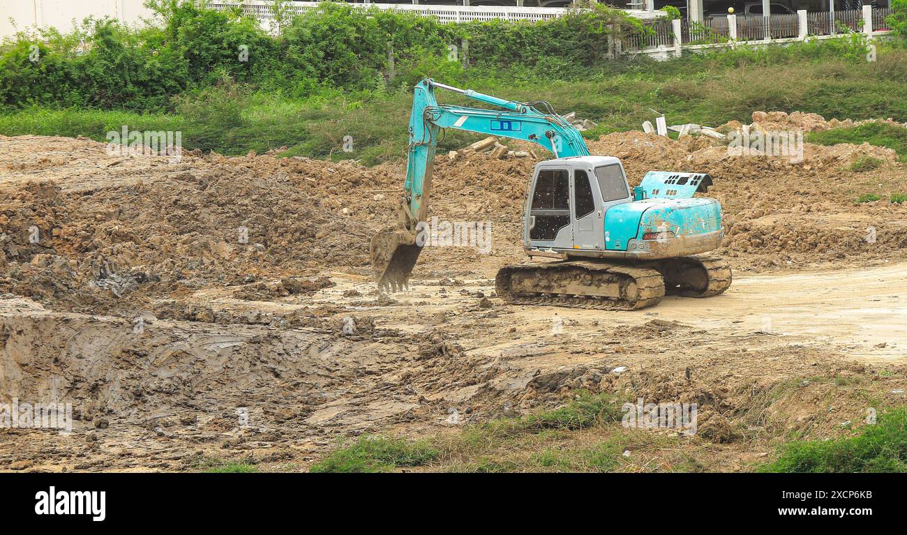 Trapano a terra, trapano pneumatico, lavori da escavatore in cantiere. Foto Stock