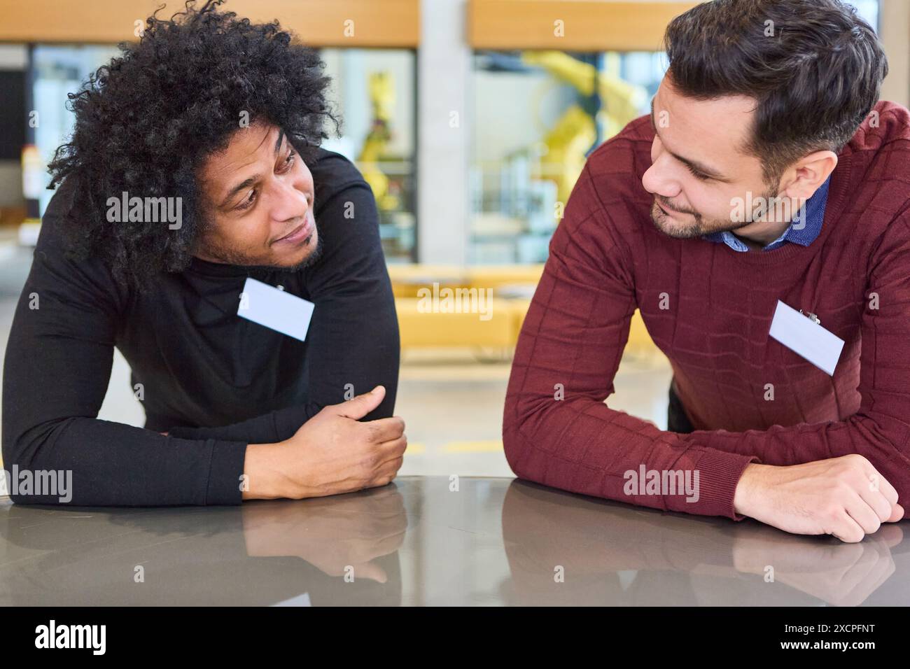 Due professionisti si sono impegnati in una discussione durante una sessione di formazione sulla robotica e l'automazione. Foto Stock