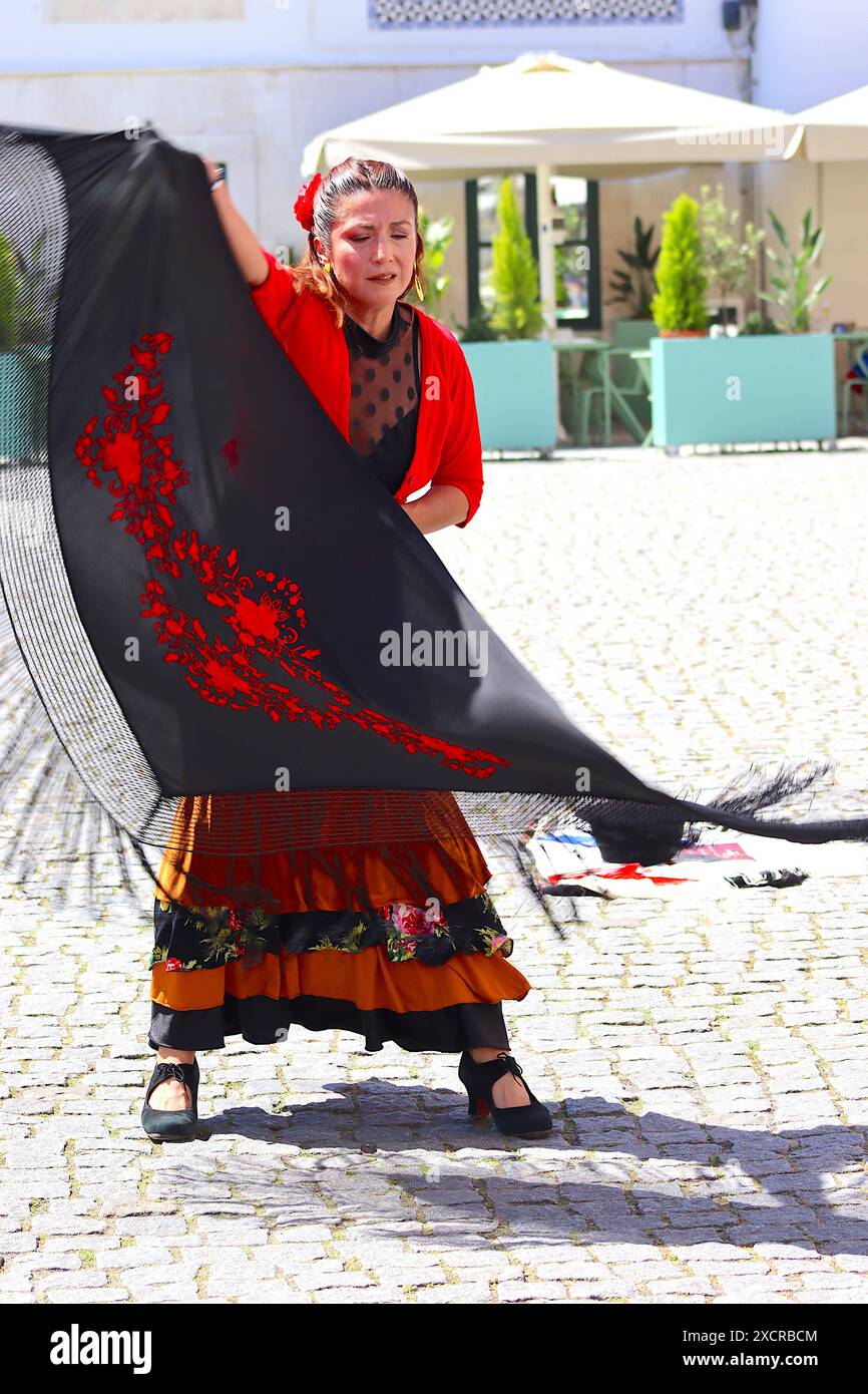 Intrattenendo gli spettatori e i turisti in una strada di Lisbona, Gloria Rios si esibisce alla folla con un tradizionale costume di flamenco nel caldo di mezzogiorno. Foto Stock