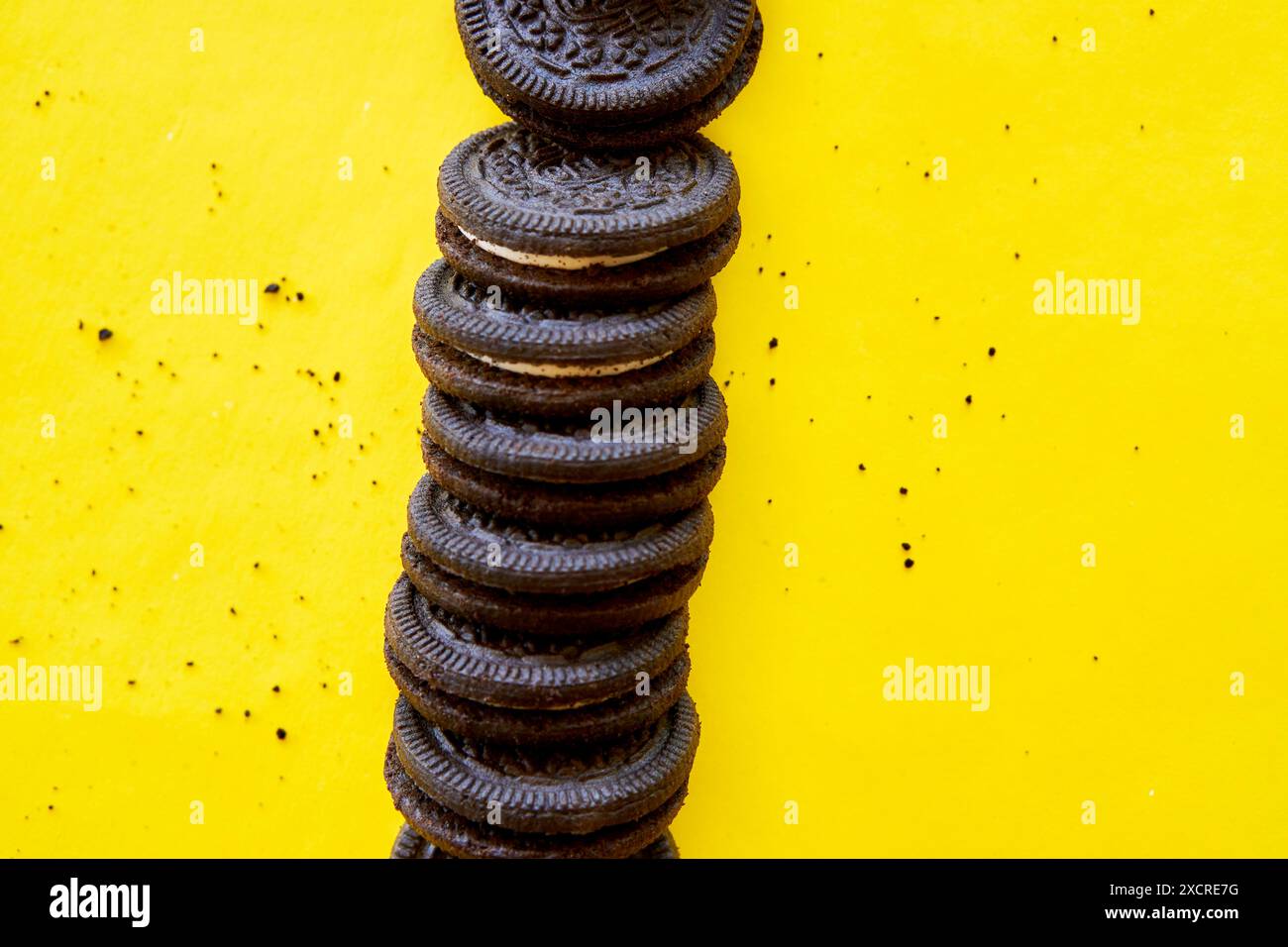 colonna di biscotti al cioccolato ripieni su sfondo giallo Foto Stock