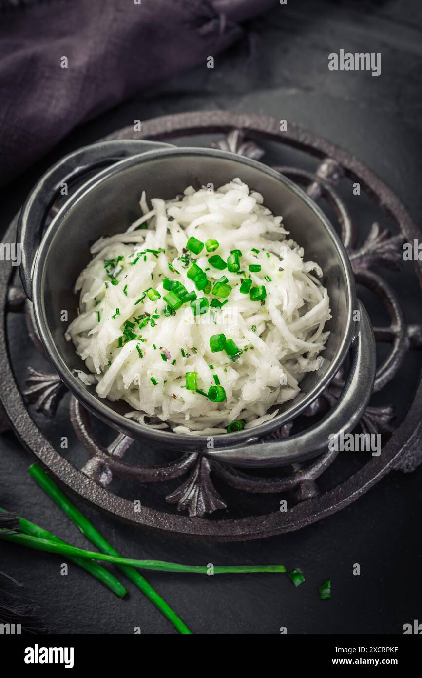 Insalata fatta in casa di rape bianche grattugiate con condimento di yogurt e erba cipollina Foto Stock