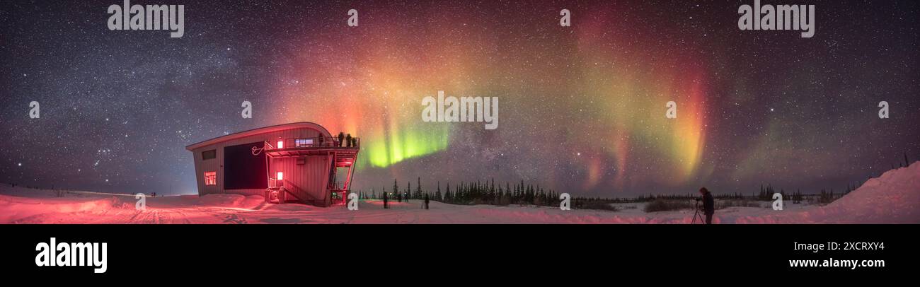 Si tratta di un panorama di un'aurora tenue ma colorata con tende rosse evidenti alla fotocamera, nonché frammenti verdi e tinte di giallo, che scagliano l'arco Foto Stock