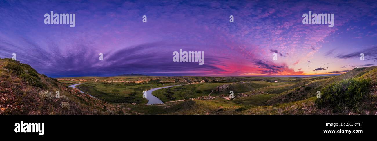 Un panorama del paesaggio e del cielo al tramonto al Writing-on-Stone Provincial Park (Áísínai'pi) in Alberta, con il fiume Milk sottostante che si snoda tra Foto Stock