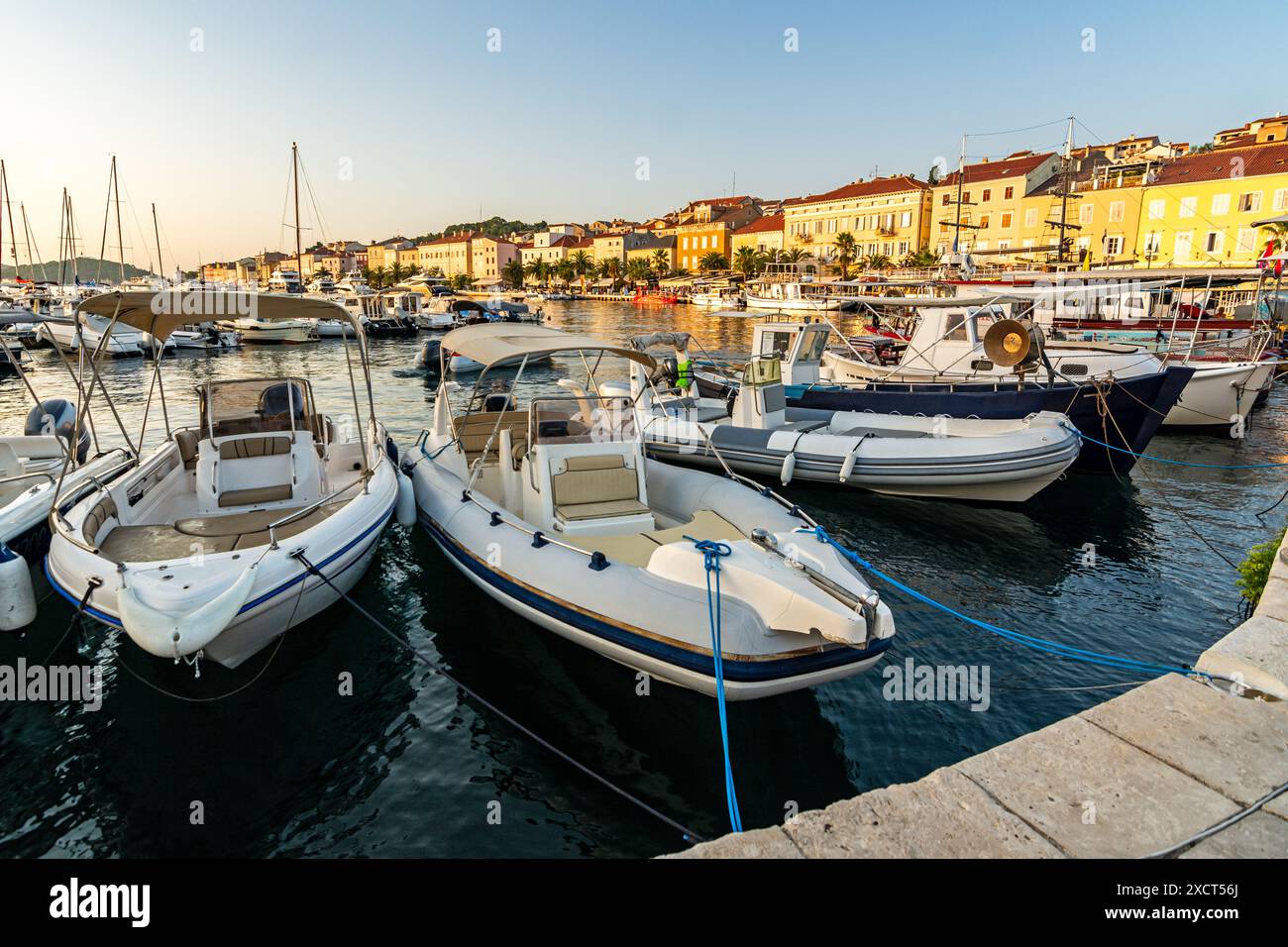 Barche al tramonto nel porto turistico di Mali sull'isola di Lussino nel mare Adriatico, Croazia Foto Stock