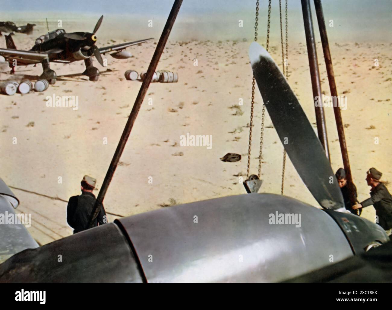 Una fotografia mostra il personale dell'Aeronautica tedesca (Luftwaffe) che sta preparando il volo in Africa durante la seconda guerra mondiale. Questi preparativi furono cruciali per garantire che gli aerei fossero pronti per le missioni nelle difficili condizioni del teatro nordafricano. La Luftwaffe giocò un ruolo fondamentale nel sostenere l'Afrika Korps, condurre ricognizioni, fornire supporto aereo e impegnarsi in operazioni di combattimento per ottenere la superiorità aerea e interrompere le linee di rifornimento alleate. Foto Stock