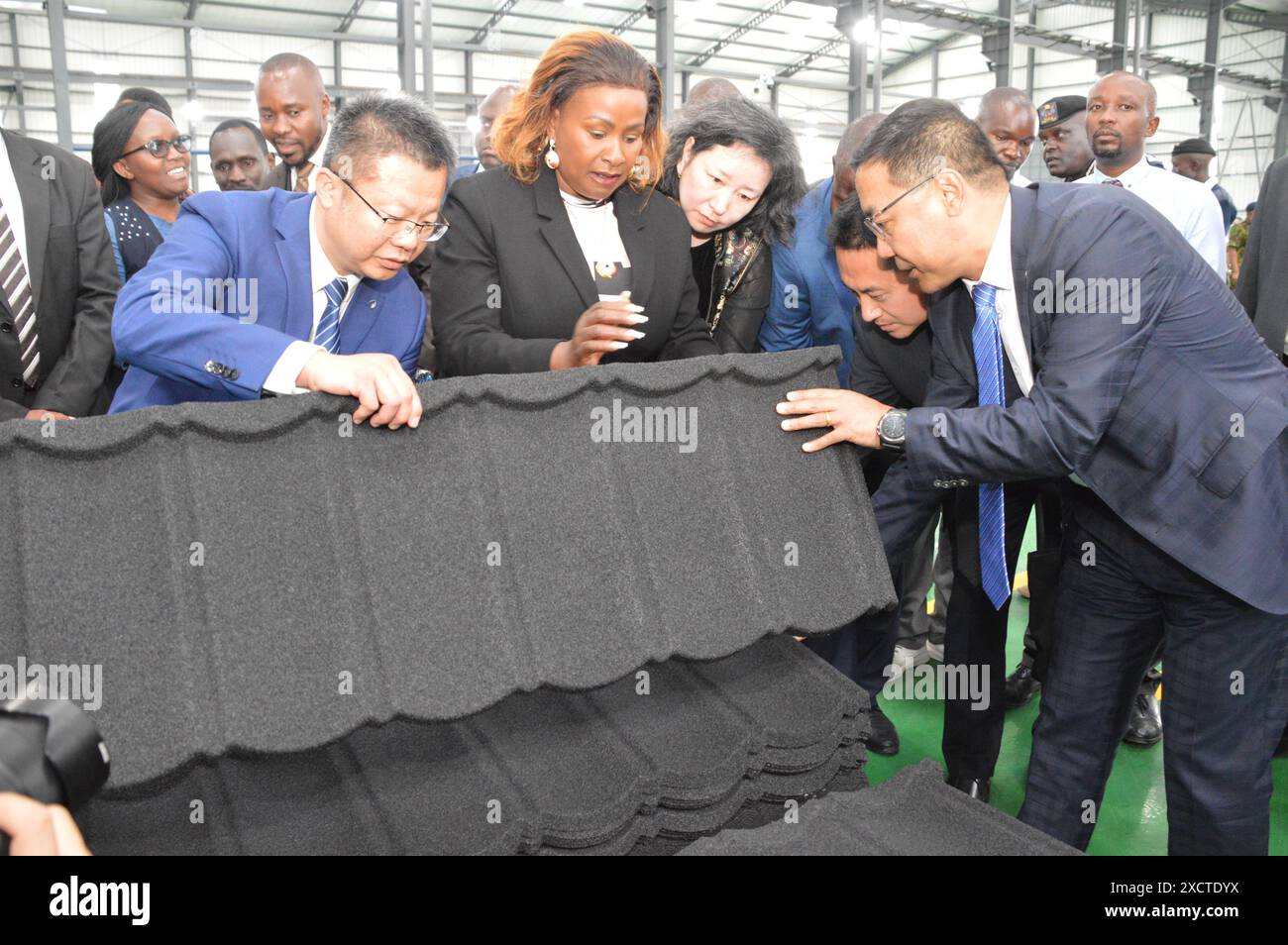 Machakos, Kenya. 18 giugno 2024. Wu Shuang (1st L, Front), direttore generale della SINOMA Roofing Company, e Zhang Sicai (1st R, Front), direttore generale della CBMI Construction Co., Ltd., presentano un prodotto a Wavinya Ndeti (2nd L, Front), governatore della contea di Machakos, nella contea di Machakos, Kenya, il 18 giugno 2024. Martedì scorso, una società cinese di tetti ha aperto una nuova fabbrica in Kenya per fornire al mercato materiali per tetti sostenibili, ecocompatibili e sostenibili. Crediti: Charles Onyango/Xinhua/Alamy Live News Foto Stock