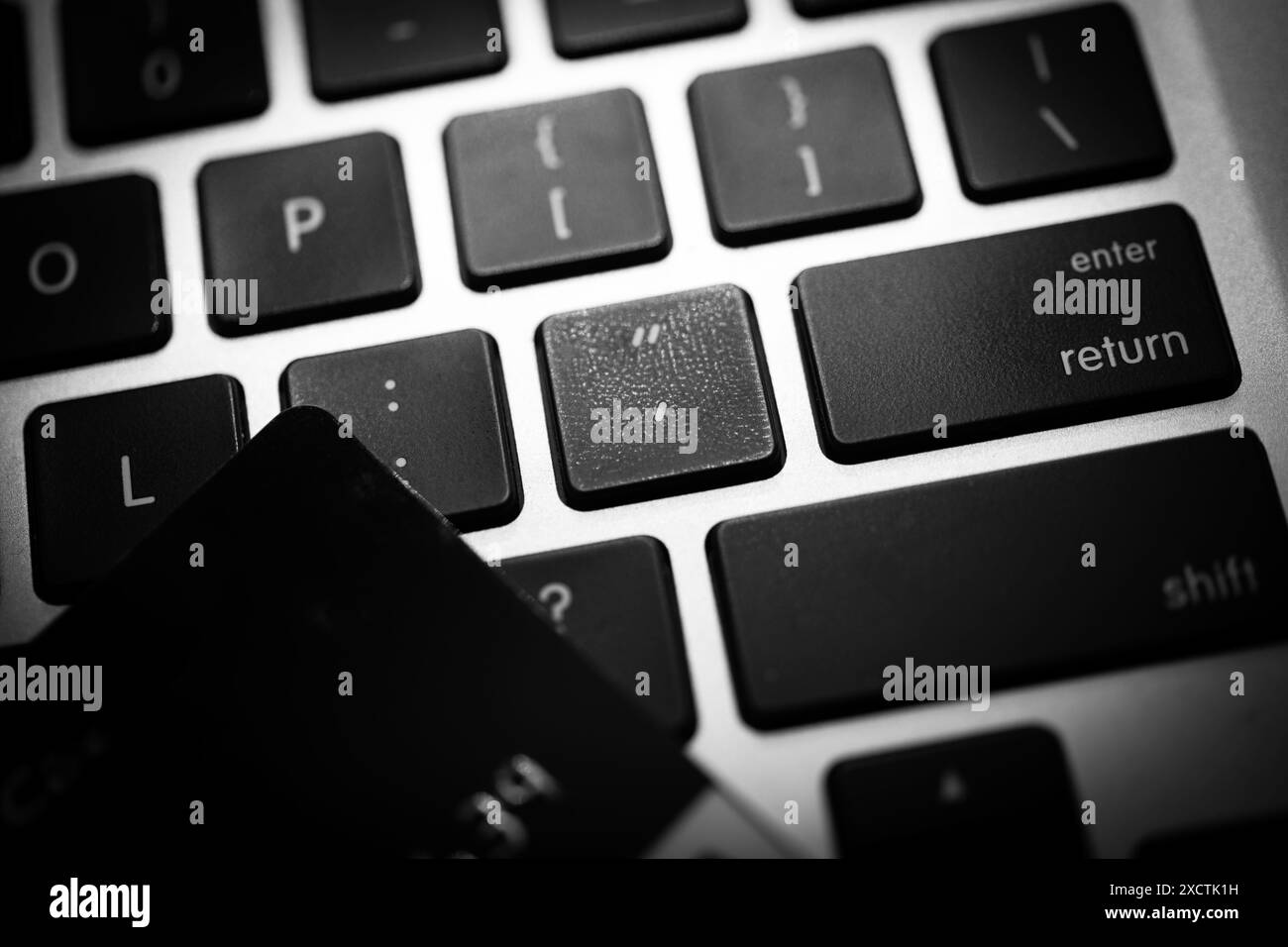 Immagine in bianco e nero con tastiera e carta di credito, che simboleggia le misure di sicurezza coinvolte nelle transazioni di e-commerce, malware e virus Foto Stock