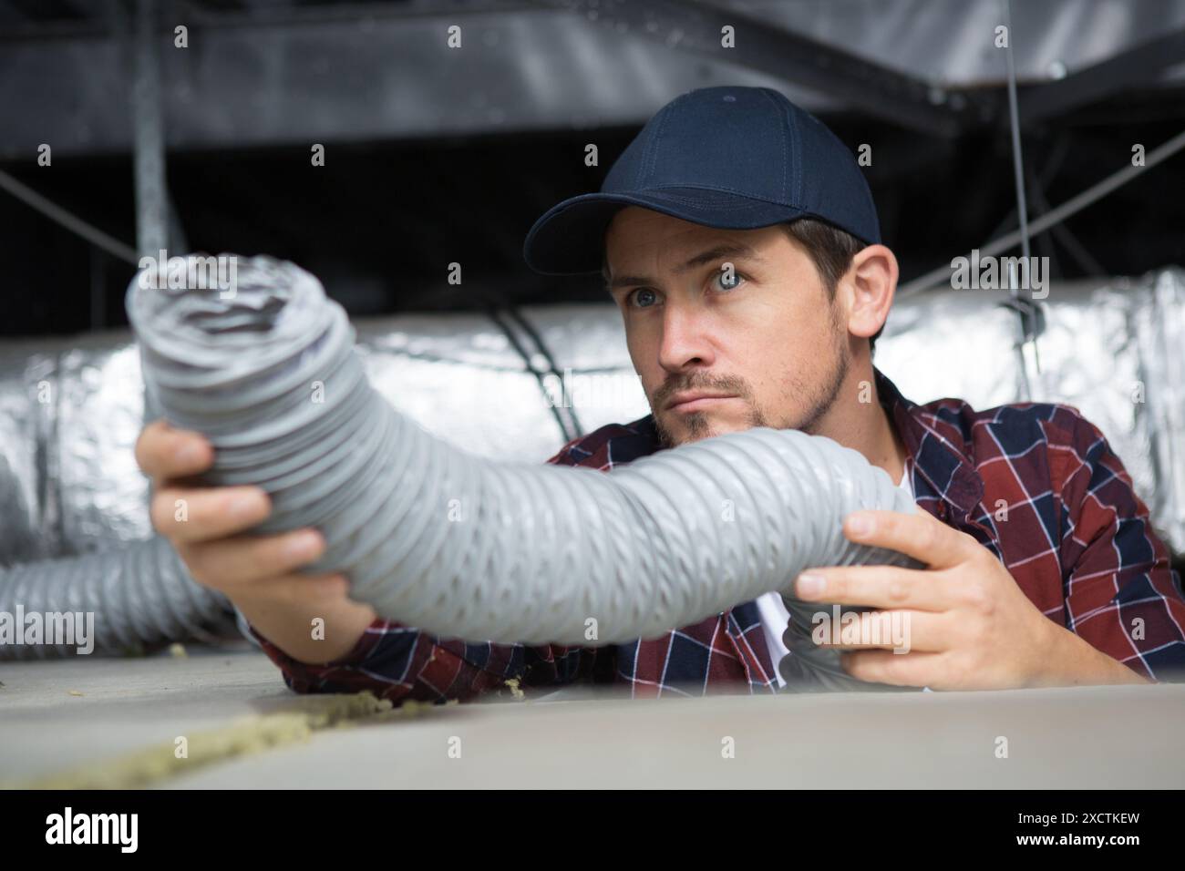 operatore che tiene il tubo flessibile di ventilazione Foto Stock