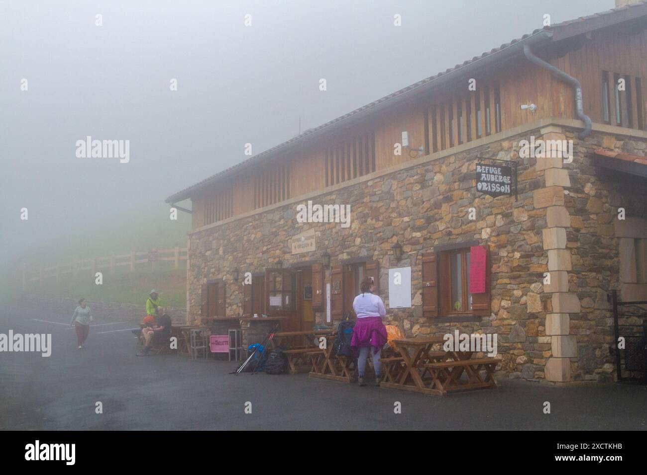Pellegrini che camminano lungo il cammino di Santiago, lungo la via di San Giacomo, in condizioni di nebbia umida sui Pirenei francesi, presso l'Albergue de Orisson Foto Stock