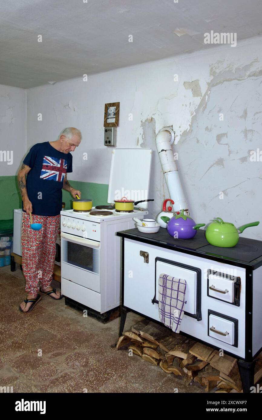 un uomo maturo britannico espone in abiti appropriati cucinando un pasto nella sua cucina per i compagni espatriati della contea di zala in ungheria Foto Stock