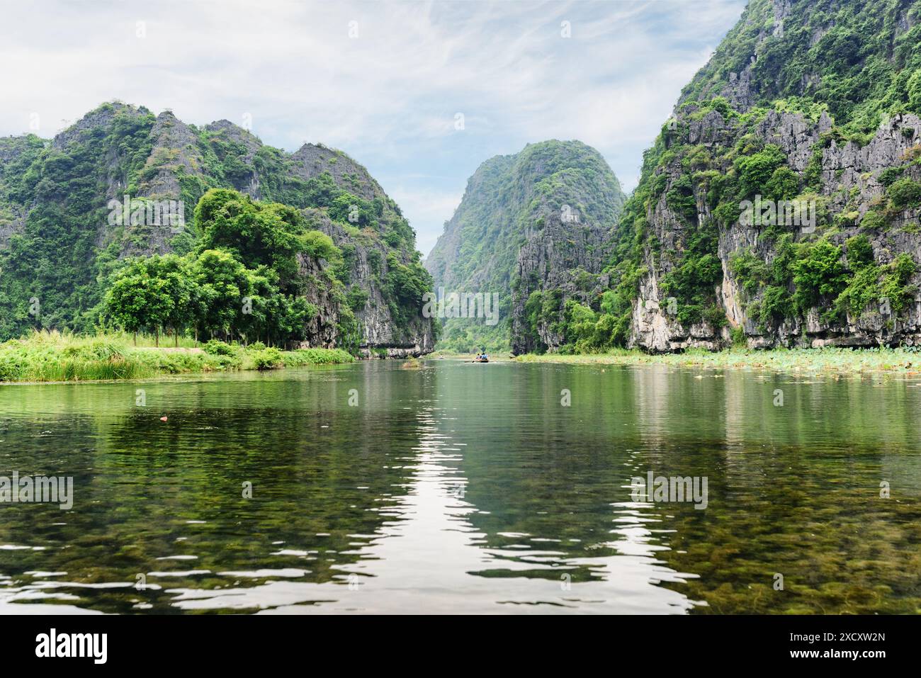 Splendida vista delle torri carsiche naturali riflesse nell'acqua del fiume NGO Dong presso la porzione di Tam Coc, provincia di Ninh Binh, Vietnam. Foto Stock