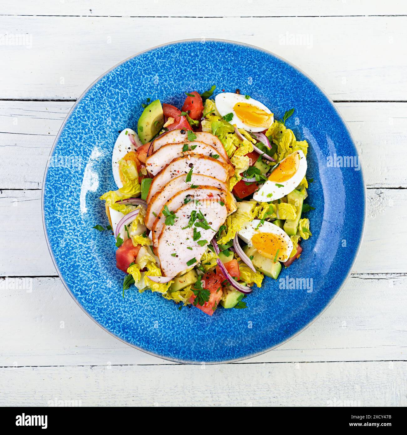 Insalata di pollo sana. Insalata fresca con avocado, pomodoro, pollo ed erbe aromatiche. Vista dall'alto Foto Stock