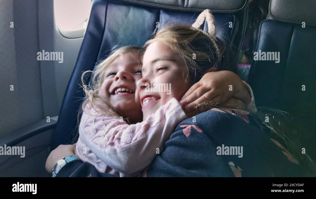 fratelli stretti che si avvolgono nel sedile dell'aereo. Sono davvero felici perché attendono con ansia di arrivare alla loro destinazione di vacanza, così desiderosi Foto Stock