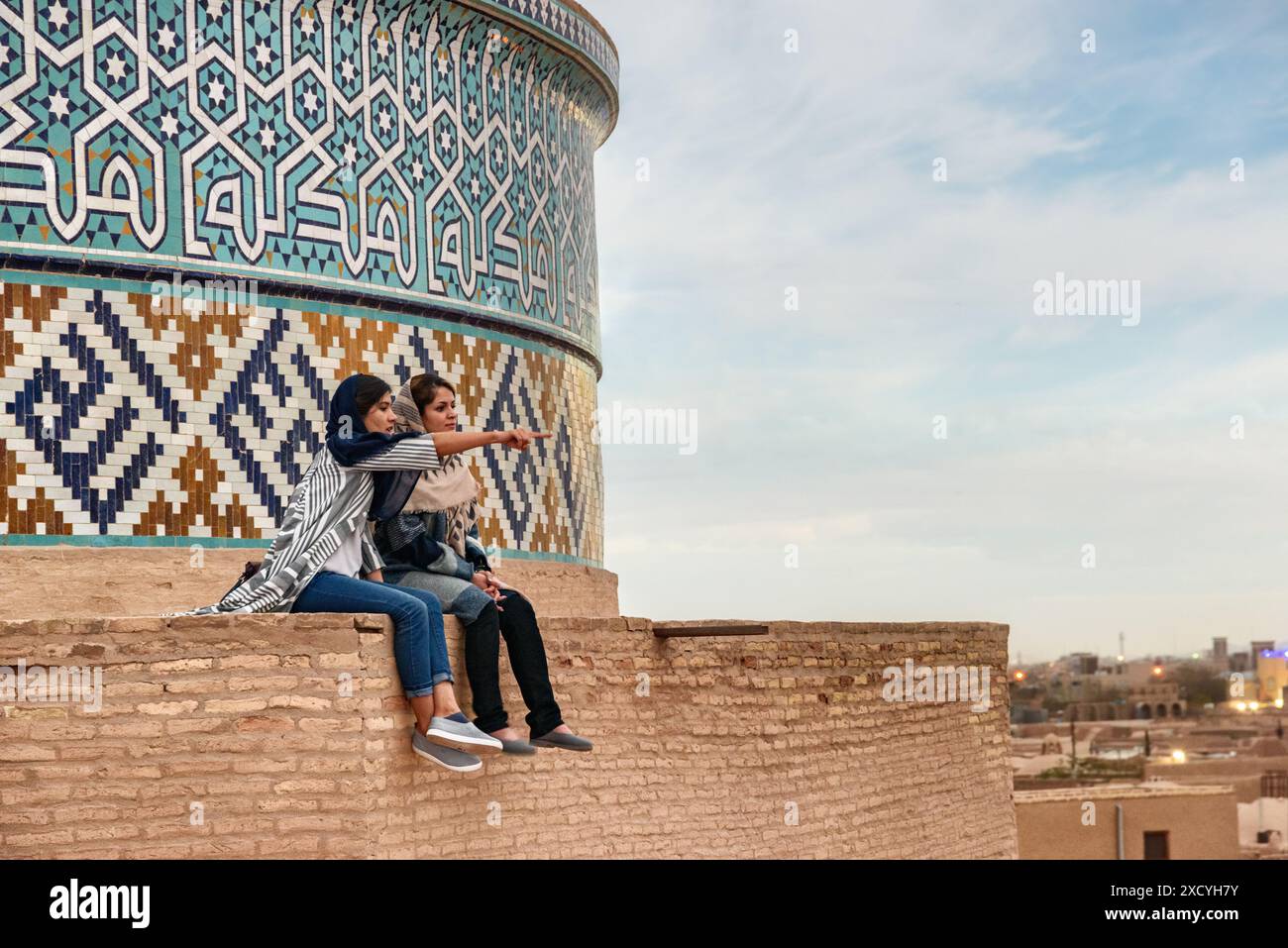 Yazd, Iran - 27 ottobre 2018: Due giovani donne iraniane godono di una vista panoramica dal tetto della Moschea Jameh di Yazd. Foto Stock