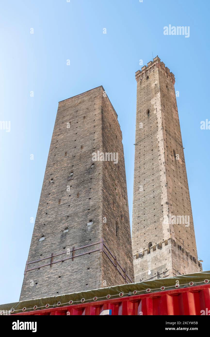 Le antiche torri Asinelli e Garisenda, simbolo di Bologna, sono chiuse da barriere rosse per lavori di restauro in corso Foto Stock