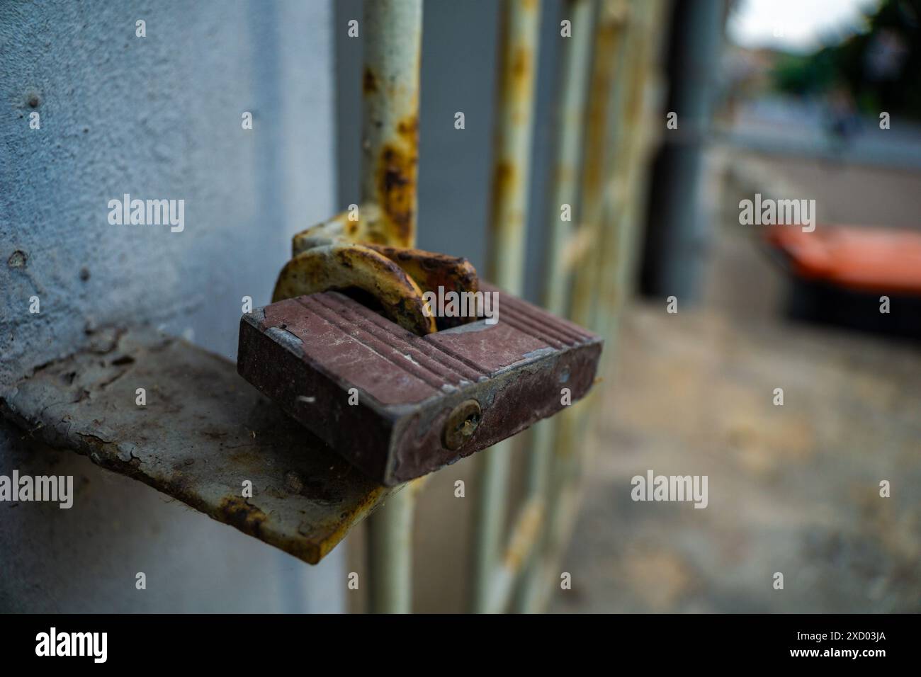 Primo piano di un lucchetto arrugginito che fissa un cancello metallico. Concetto di sicurezza Internet ad accesso limitato, nessun segreto d'ingresso Foto Stock