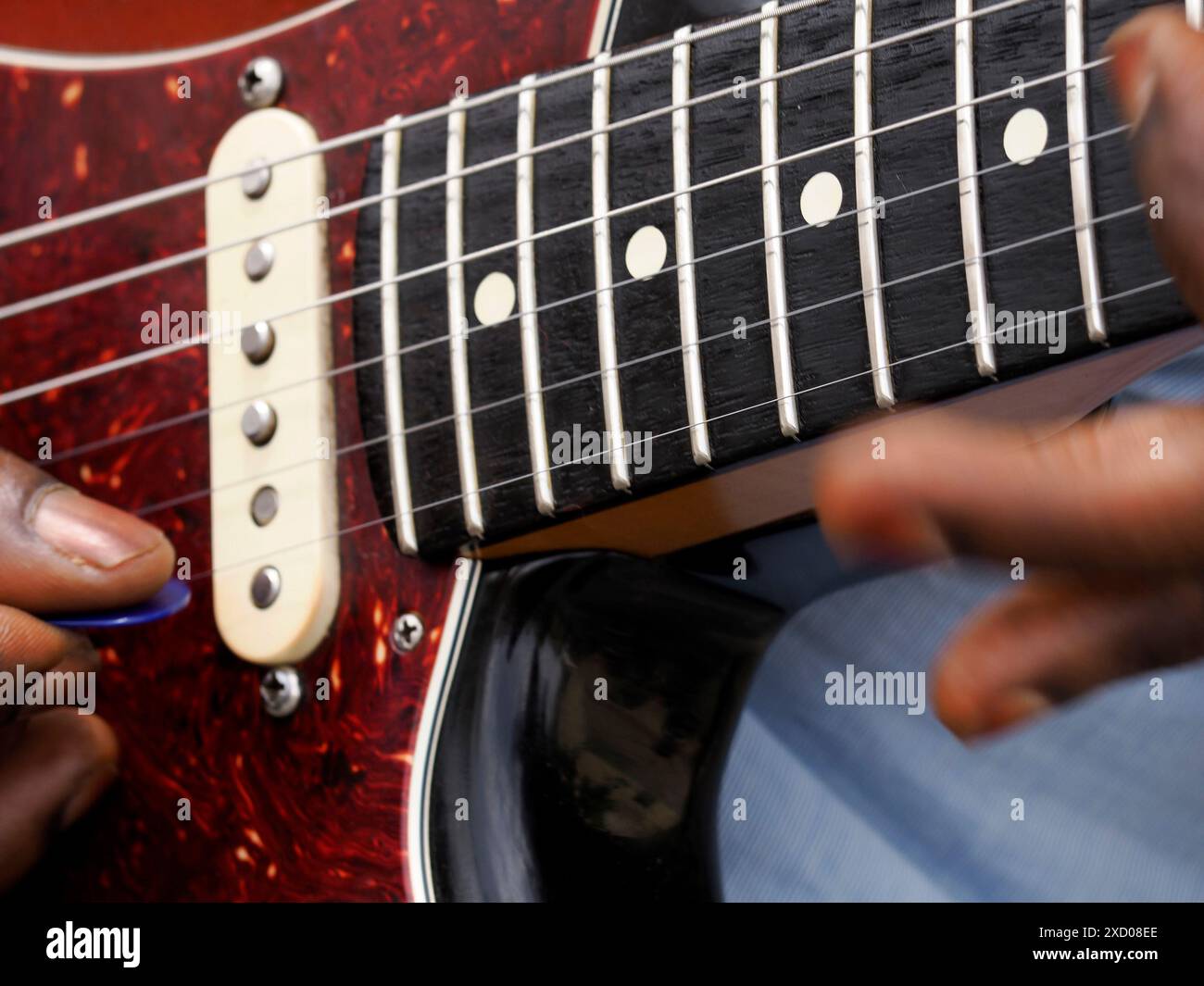 Le mani di un uomo nero che suona la chitarra da vicino Foto Stock