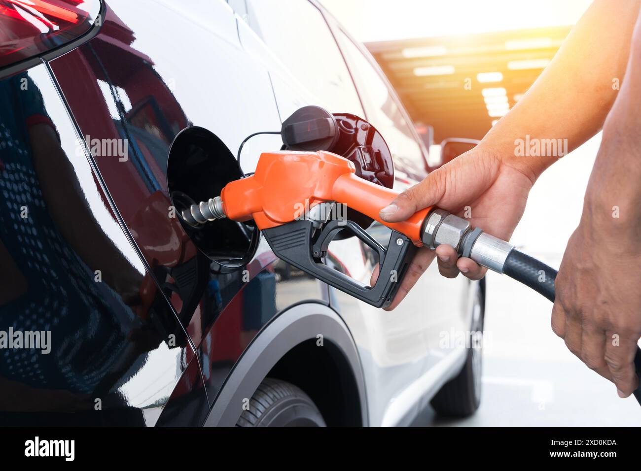 Il rifornimento di carburante della macchina in corrispondenza di una stazione di rifornimento della pompa del combustibile. Man mano driver di riempimento e di pompaggio olio di benzina la vettura con il carburante alla stazione di rifornimento. Il rifornimento di carburante per auto Foto Stock