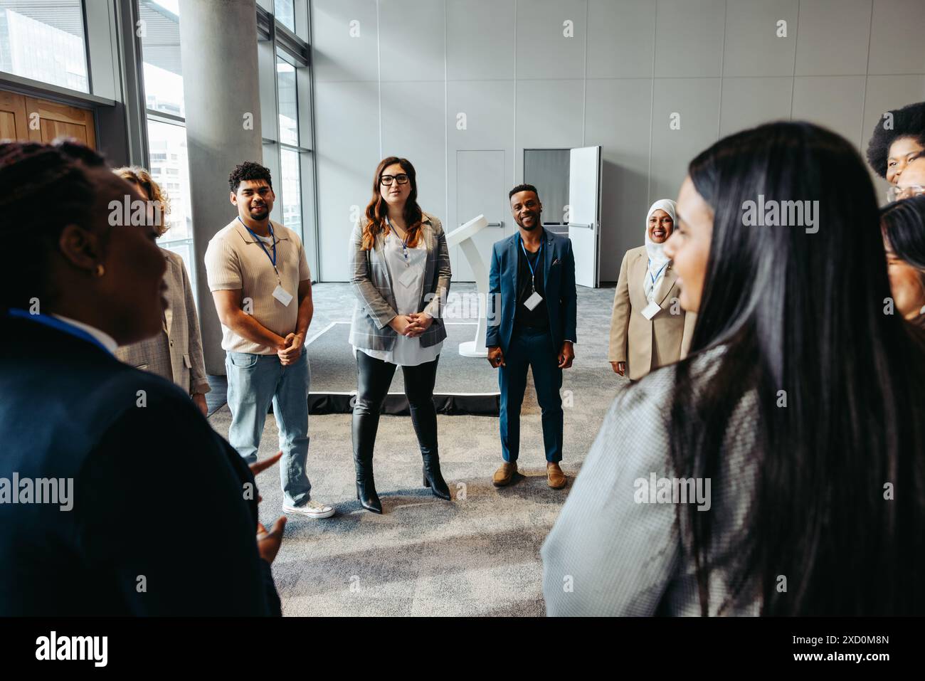 Un gruppo eterogeneo di professionisti impegnati in una discussione di team building in un ambiente di ufficio moderno. Ambiente di lavoro collaborativo e inclusivo Foto Stock