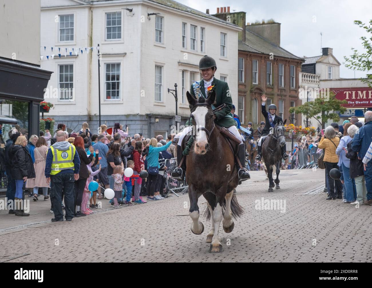 Il 15 giugno 2024, come parte degli eventi del GUID Nychburris, altri cavalieri a cavallo si dirigono lungo Dumfries High Street, centro città, Scozia. Foto Stock