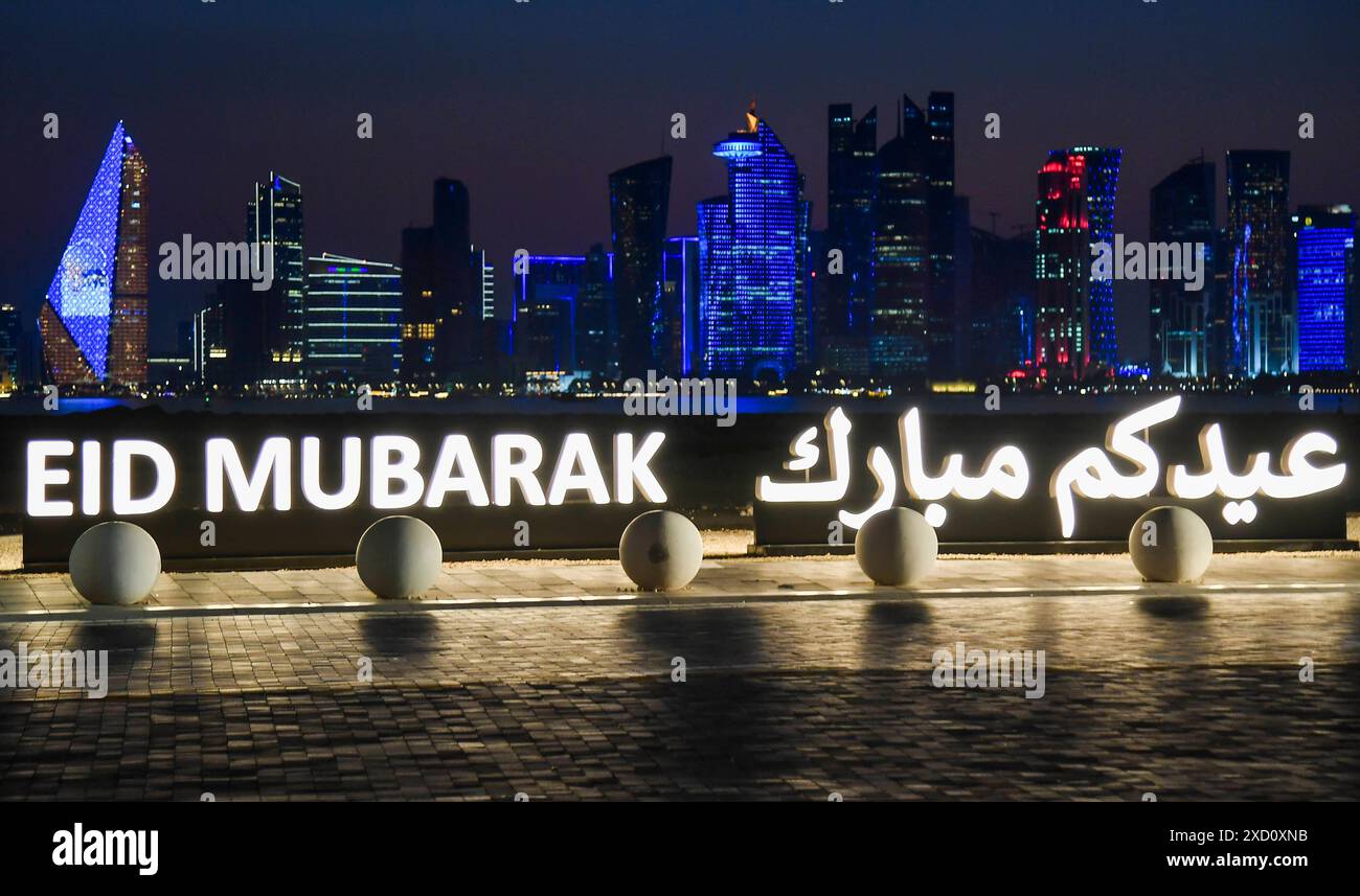 QATAR METEO 2024 lo skyline di Doha è visto dietro un'installazione che segna le celebrazioni di Eid al-Adha ÒEID MUBARAKÓ al vecchio porto di Doha, Qatar il 19 giugno 2024 DOHA QATAR Copyright: XNOUSHADx Foto Stock