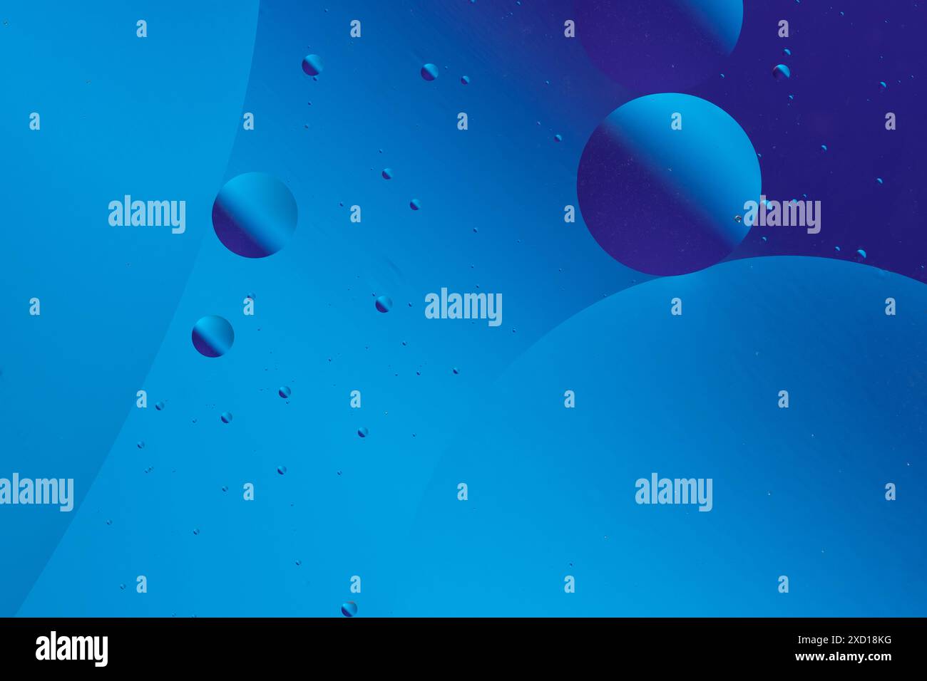 Design astratto e minimalista con bolle blu e viola di diverse dimensioni su sfondo blu scuro Foto Stock