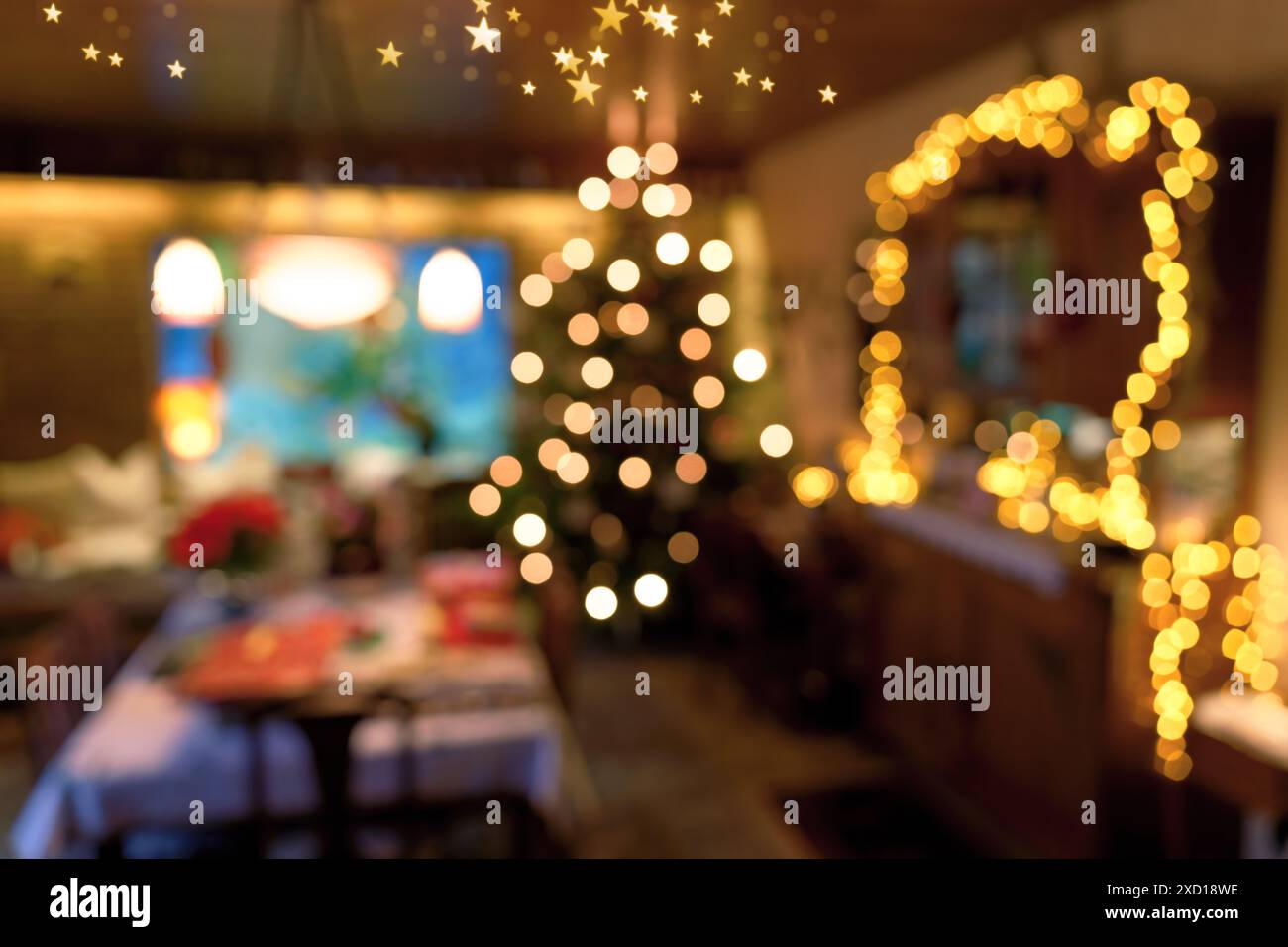 Immagine dall'atmosfera sfocata e grandangolare di un concetto di illuminazione di una stanza durante il periodo natalizio, con albero di Natale, plafoniere e alcune luci a LED delle fiabe Foto Stock
