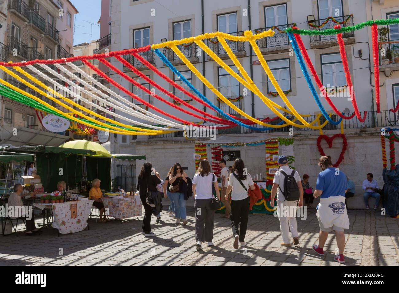 Feste popolari dei Santi a Lisbona, Portogallo. Persone che camminano per le strade di Alfama con decorazioni tipiche colorate Foto Stock