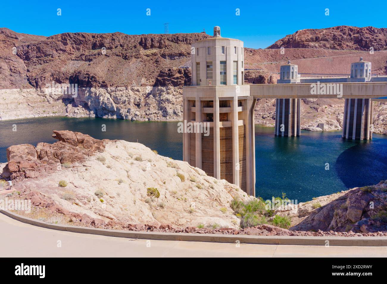 Vista ravvicinata delle strutture di presa d'acqua della diga di Hoover che torreggiano contro i terreni robusti e il cielo blu. Foto Stock