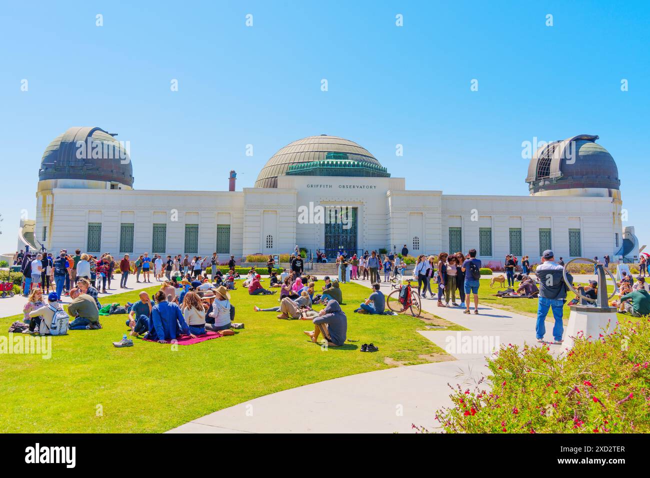 Los Angeles, California - 8 aprile 2024: Le persone si riuniscono per osservare un'eclissi solare al Griffith Park, con lo storico osservatorio Griffith alle spalle Foto Stock