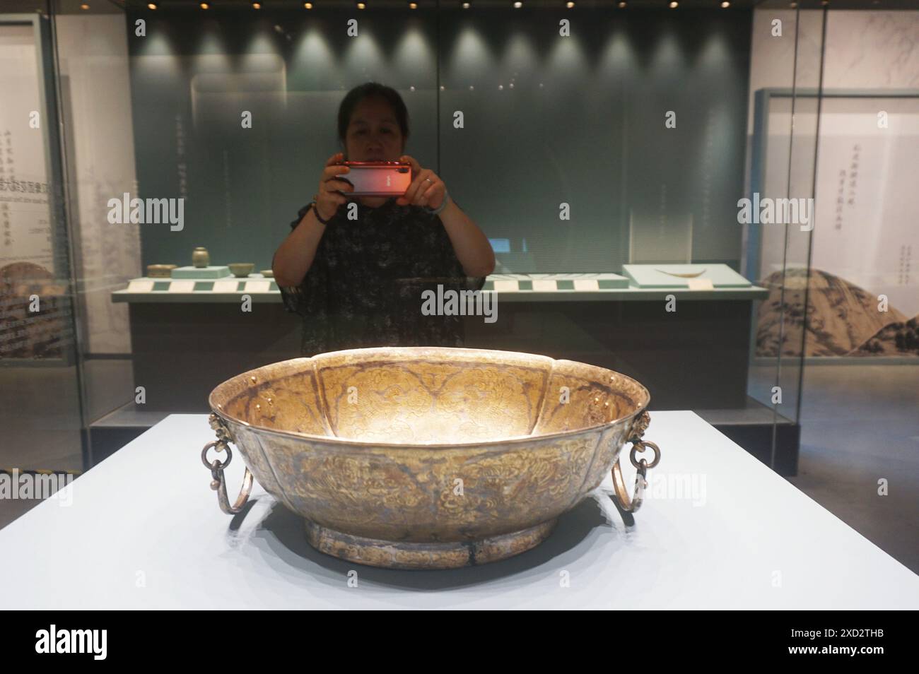 HANGZHOU, CINA - 20 GIUGNO 2024 - i visitatori del Museo della seta cinese visitano un grande bacino d'argento con un motivo a doppia anatra della dinastia Tang a Hangzhou, EA Foto Stock