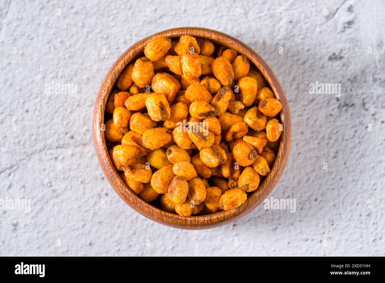 Noci di mais arrosto con salsa in un recipiente di legno su un tavolo in pietra bianca Foto Stock