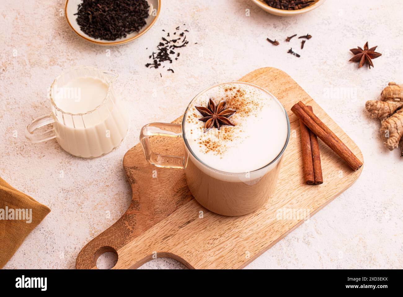 Dall'alto, delizioso chai latte con schiuma cremosa e anice stellato in stile rustico Foto Stock