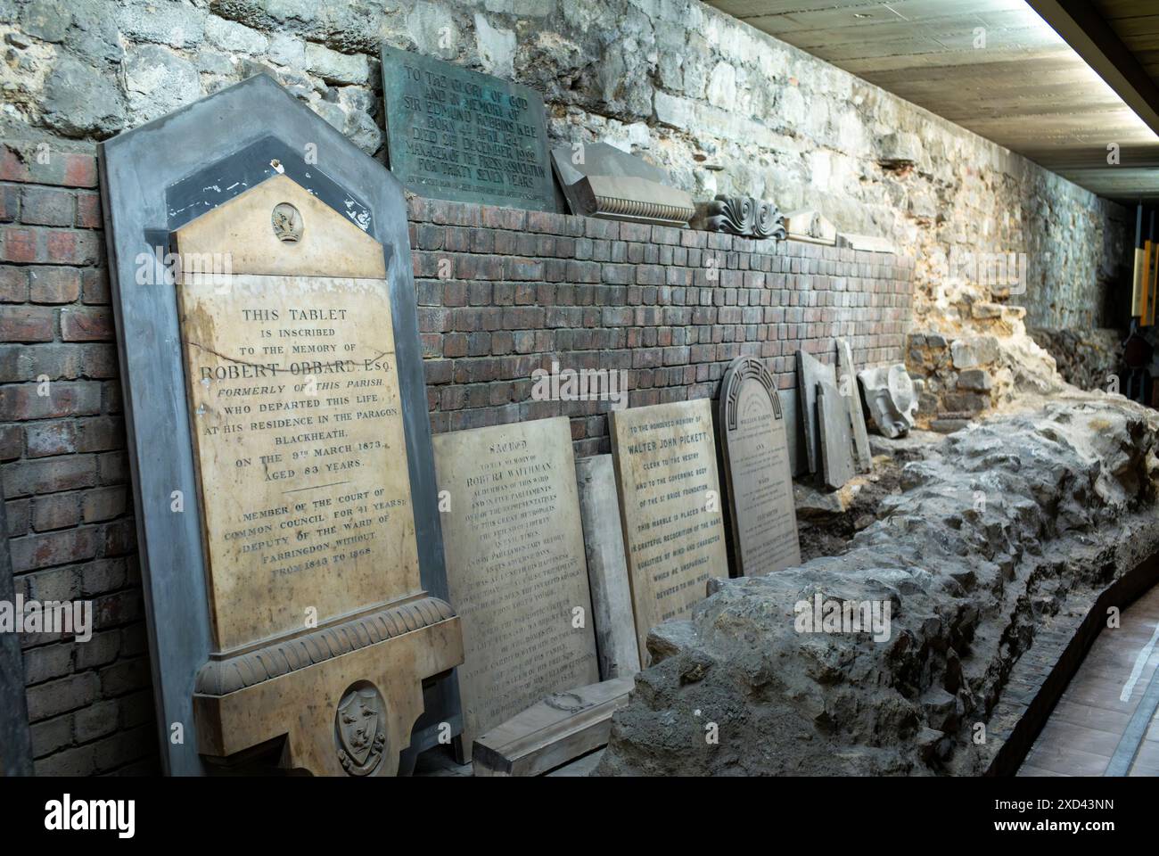 Una sezione di mura romane e vecchie lapidi in mostra nella cripta della St Bride's Church, o The Journalists' Church, in Fleet Street, Londra, Regno Unito Foto Stock
