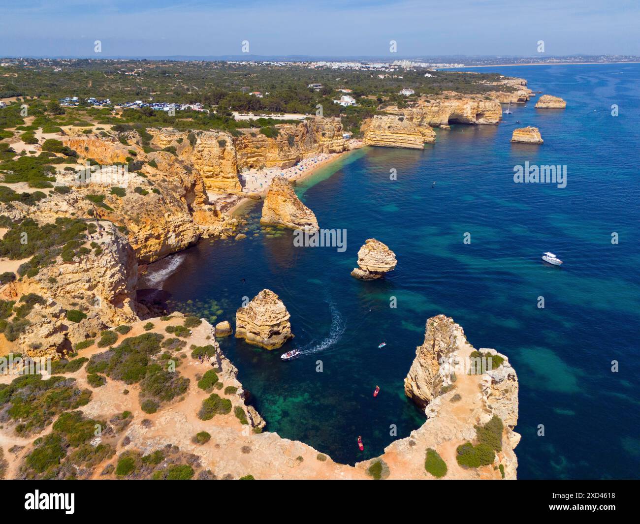 Vista aerea di un aspro paesaggio costiero con isole rocciose e barche in acque turchesi, spiaggia, Praia da Marinha, Lagoa, Algarve rocciosa, Algarve Foto Stock