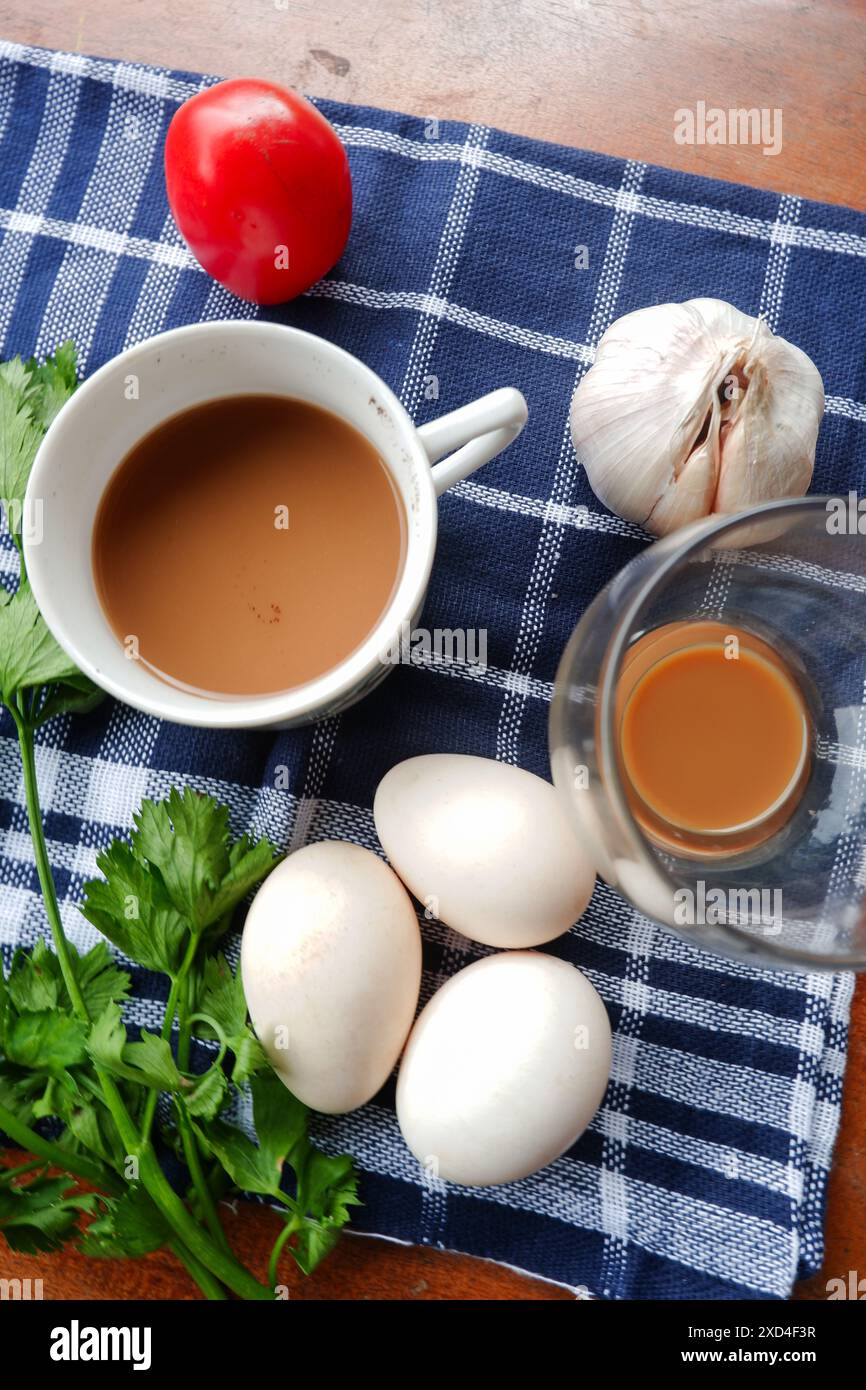 La foto è una foto di diversi ingredienti come uova, pomodori, aglio e foglie di sedano Foto Stock