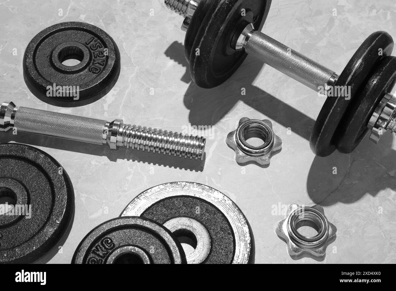 Barbell e parti di uno su pavimento grigio, vista dall'alto Foto Stock