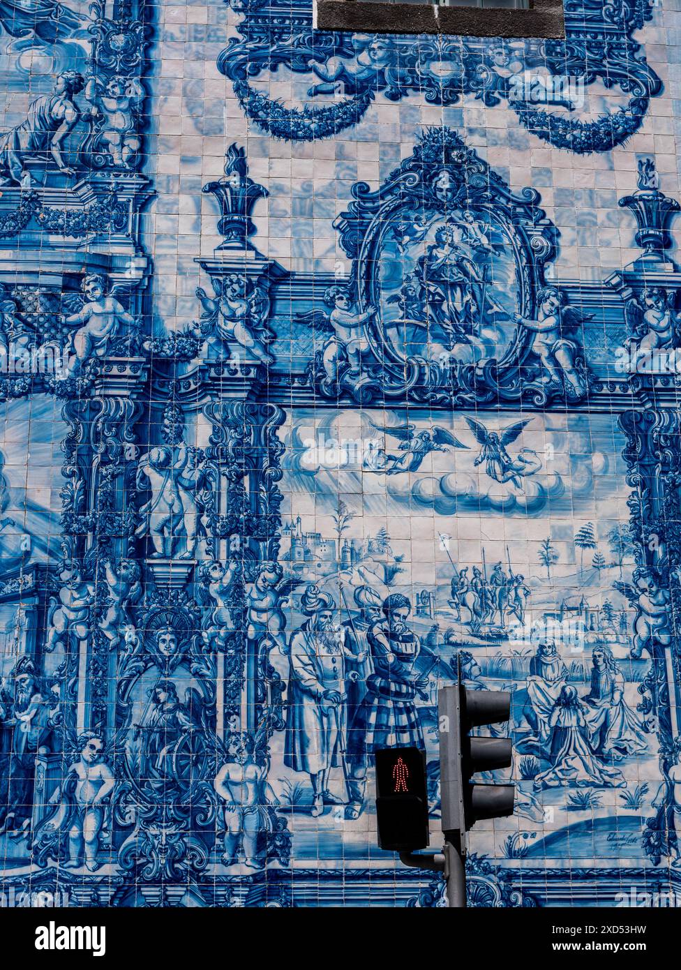 Bella azulejos e semaforo a Porto. Muro esterno di una chiesa di Porto, Portogallo. La parete è riccamente adornata da azulejos dipinte in blu. IO Foto Stock