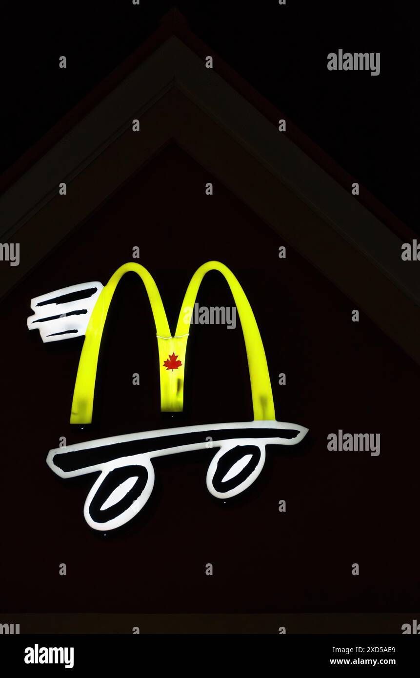 Simbolo di McDonalds illuminato di notte. Foto Stock