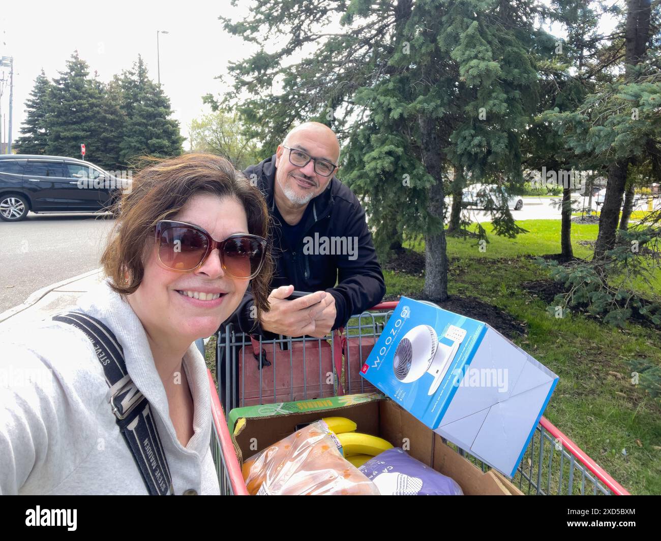 Selfie ritratto della coppia con un carrello pieno di merci, Toronto, Canada Foto Stock