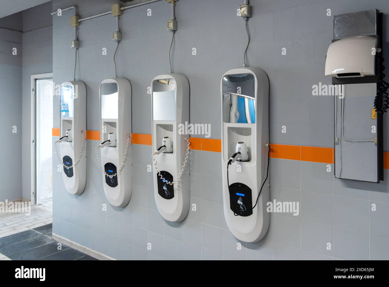 Asciugacapelli automatico sulla parete dello spogliatoio della piscina pubblica con lettore contactless per carte prepagate Foto Stock