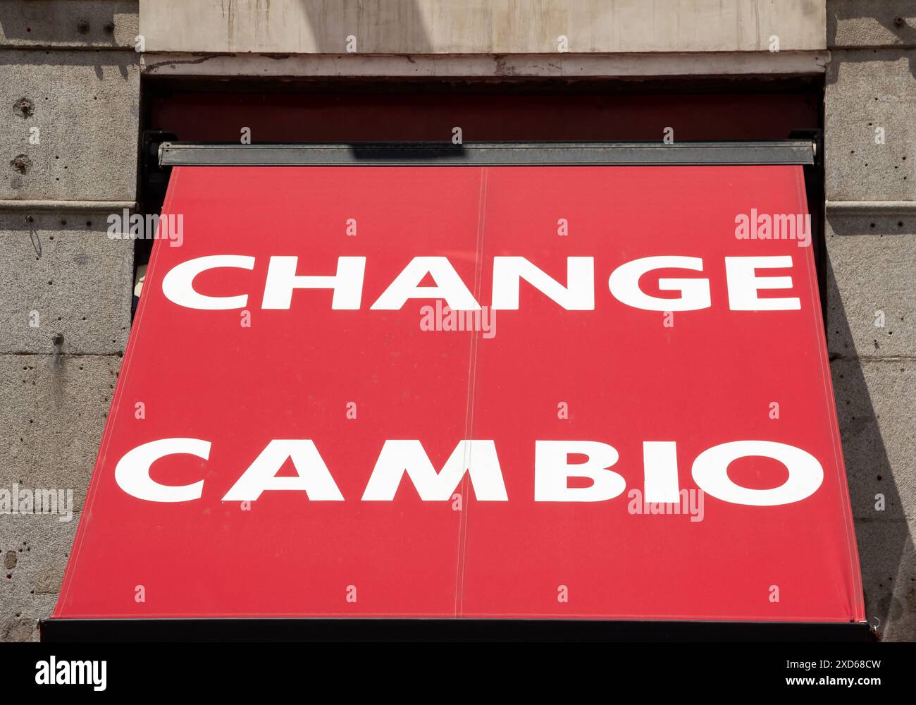 Tenda rossa con le parole "cambio" e "cambio" scritte in lettere bianche sopra la porta di un ufficio di cambio a Madrid, Spagna Foto Stock