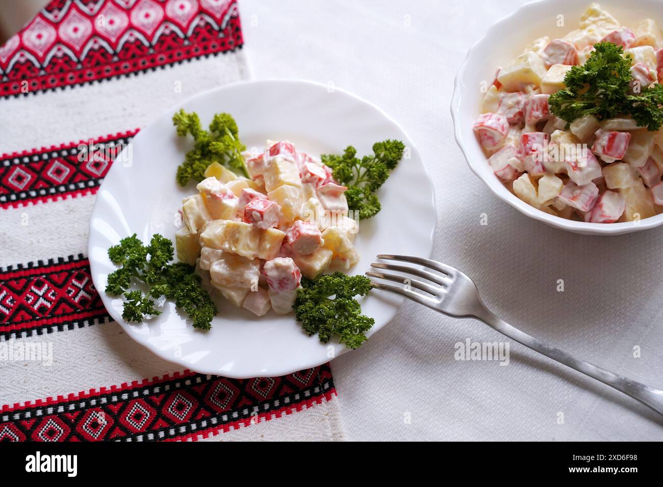 Insalata fatta in casa con bastoni di granchio tipica della moderna cucina Ucraina e di altre cucine dell'Europa orientale piatti tradizionali ucraini sul tavolo con Foto Stock